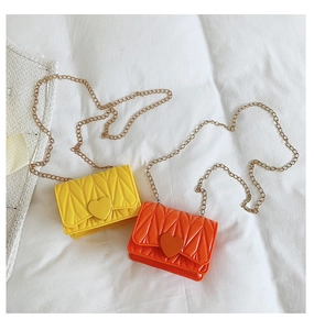 Detail of mini quilted crossbody bags in yellow and orange with heart magnetic buckle