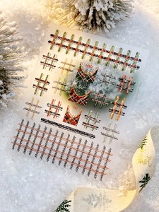Macro detail of Christmas plaid nail stickers with red and green tartan patterns