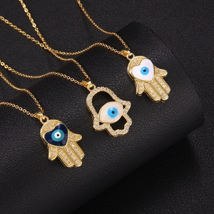 Gold Hamsa Hand necklaces with blue and white evil eye charms and sparkling zircon accents