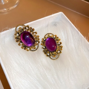 Detailed close-up of French vintage oval purple stone earrings with gold floral frames