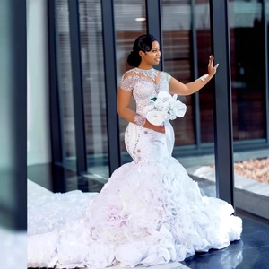 Elegant mermaid lace wedding dress with beaded sequins and long ruffled train overlay