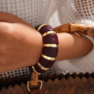 Détail du bracelet extensible large avec modules acryliques bordeaux et segments dorés