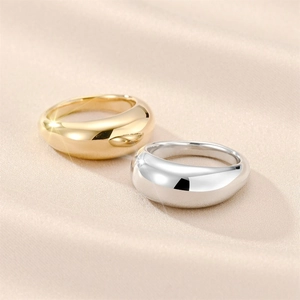 Polished teardrop titanium steel rings in gold and silver finish on champagne silk