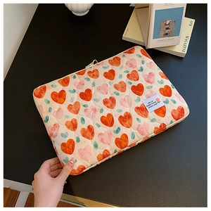 Quilted laptop sleeve with colorful heart patterns and unique HELLO label detail