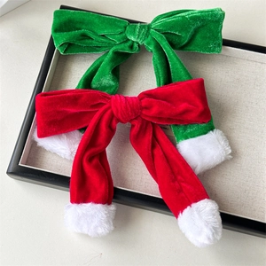 Christmas velvet hair clips in red and green with plush trim on a beige tray