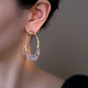 Boucles d'oreilles minimalistes en résine plaquée or 18k portées par un mannequin