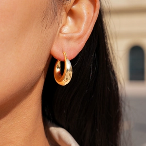 Minimalist 18k gold plated chunky hoop earrings worn by a model in natural light
