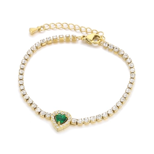 Golden tennis bracelet with green heart gemstone and white zircon stones on white background