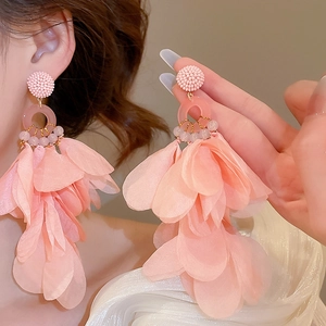 Close-up of pink fabric flower tassel earrings on model with delicate bead details