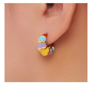 Close-up of colorful enamel bamboo splice earrings on model showing fine gold metal texture