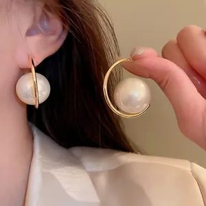 Elegant gold C-shaped hoop earrings featuring large round white pearls for women