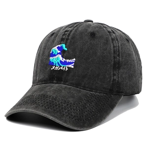 Close-up of wave embroidery and Japanese lettering on a washed black cotton baseball cap