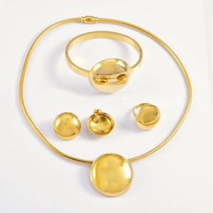 Polished gold jewelry set with necklace, bracelet, earrings and ring in a sleek minimalist design