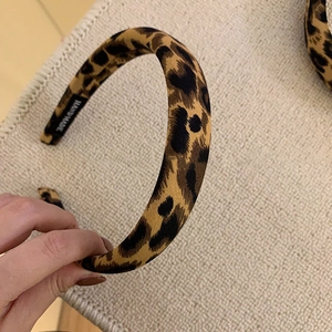 Detailed shot of leopard print fabric headband with a handmade label on inner side