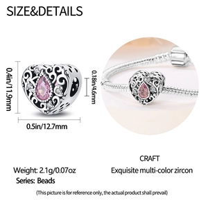 Macro detail of heart-shaped hollow bead with pink pear-cut zircon and silver filigree