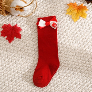 Detail of red Christmas baby knee high socks with ribbon bows and snowflake mitten charms
