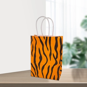 Vue détaillée d'un sac cadeau en papier kraft orange avec un motif rayé noir style tigre