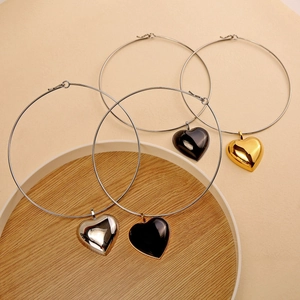 Minimalist heart pendant necklaces in silver, gold, and rose gold on a wooden tray