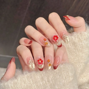 Red and gold floral press-on nails with pearls and rhinestones for New Year