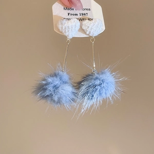 Dettaglio orecchini a cuore in tessuto con pompon grigio-blu e aste in metallo dorato