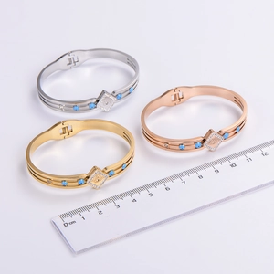 Minimalist Evil Eye bangle set in gold, silver, and rose gold with blue stone accents