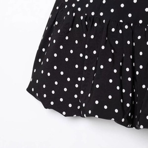 Black and white polka dot dress with asymmetrical ruffled hem and crepe texture