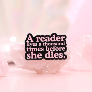 Pink enamel book series brooch with quote A reader lives a thousand lives on quartz base