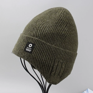 Detail of olive green ribbed knit beanie showing textured wool weave and logo tag