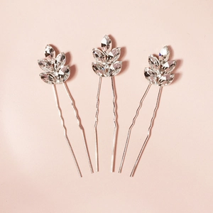 Détail de trois épingles à cheveux argentées en forme de feuille avec cristaux clairs