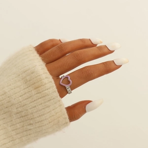 Close-up of a purple heart enamel ring with a silver chain-style band on finger