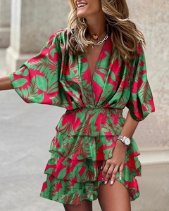 Detail of red and green leaf print on a silk-like deep V-neck ruffled tiered dress