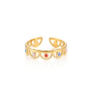 Detail of adjustable gold-plated ring featuring colorful enamel dots and lace hollow design