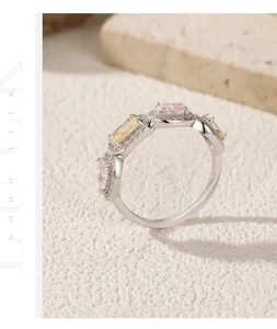 Detail of silver clover ring featuring pink and yellow crystals with lucky engraving