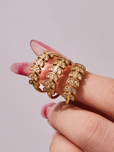Detailed close-up of wheat ear shaped gold rings with sparkling zircon inlay on hand