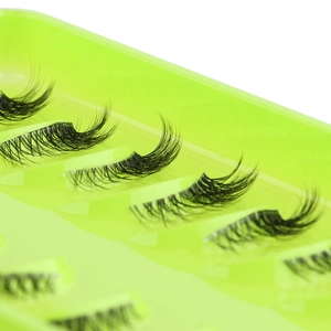 Macro shot of 10 pairs of black false eyelashes on a vibrant neon green display tray