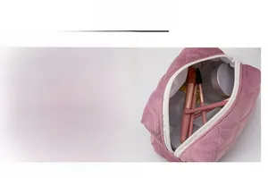 Detail of a pink corduroy quilted makeup bag showing the smooth white zipper closure