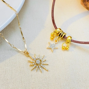 Macro detail of starburst necklace and brown leather bracelet with star pendants