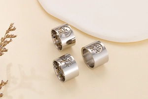 Detailed view of polished stainless steel wide bands with hollow tree of life design