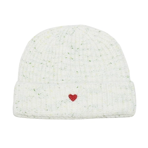 Detailed close-up of white knitted beanie featuring a red heart embroidery on the cuff