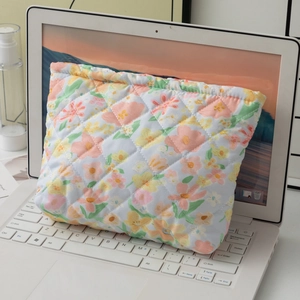 Detailed macro of the soft quilted floral pattern on a portable travel makeup bag