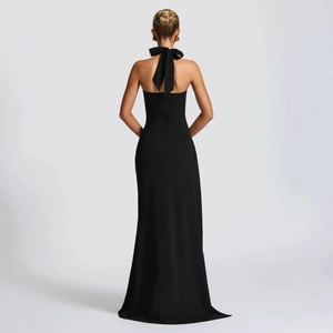 Elegant black halter backless evening gown with a large bow detail and high slit