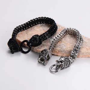 Rugged stainless steel lion head bracelets in black and silver on natural stone background