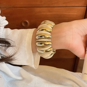 Detail of creamy marble acrylic beads and gold metal beads on a stretchy bracelet