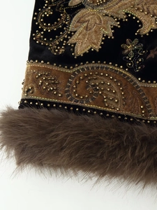 Close-up of golden beaded embroidery on black velvet vest with brown faux fur trim
