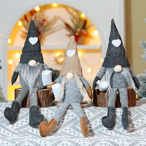 Close-up of three Christmas gnomes with knitted hats and white mugs on wooden logs