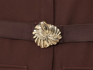 Detail of a dark brown crepe midi dress featuring a gold spiral buckle belt accessory
