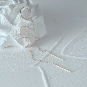 Minimalist S925 silver C-shaped tassel chain earrings hanging on white floral prop