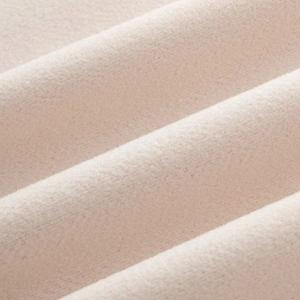 Gros plan sur la texture du tissu en laine beige montrant la douceur du matériau