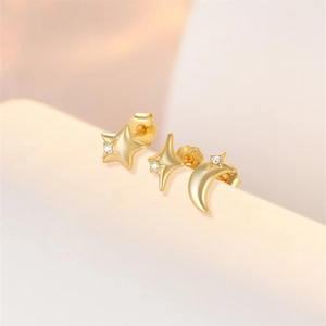 Macro shot of gold plated sterling silver star and moon stud earrings with zircon stones