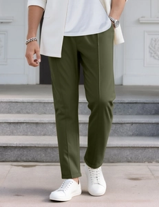 Detail einer schmal geschnittenen olivgrünen Herrenhose kombiniert mit weißen Sneakern